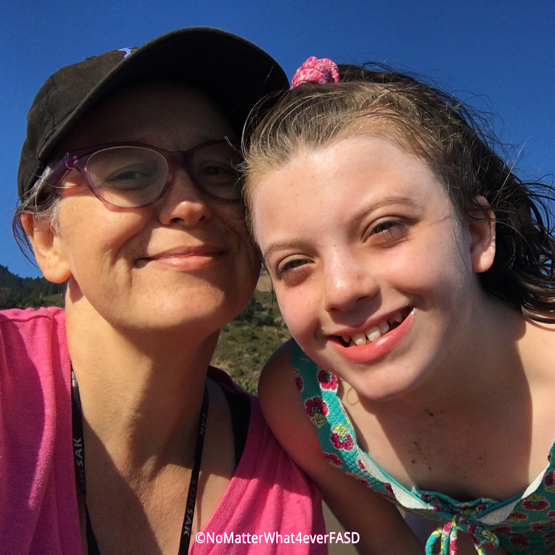 Mother and Daughter smiling with heads touching